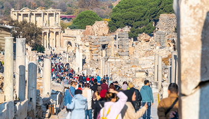 Eine lange Schlange Touristen l&auml;uft durch eine antike Ausgrabungsst&auml;tte.